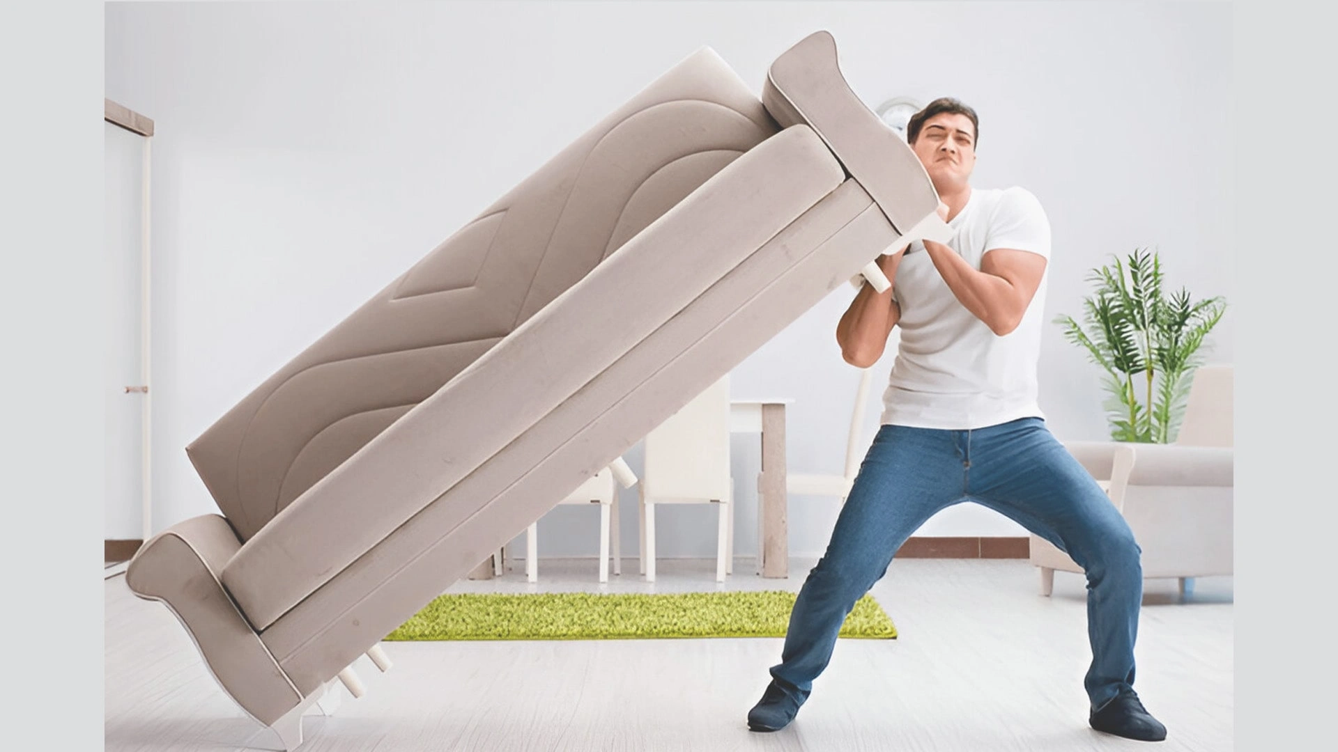 Young man struggles to carry sofa